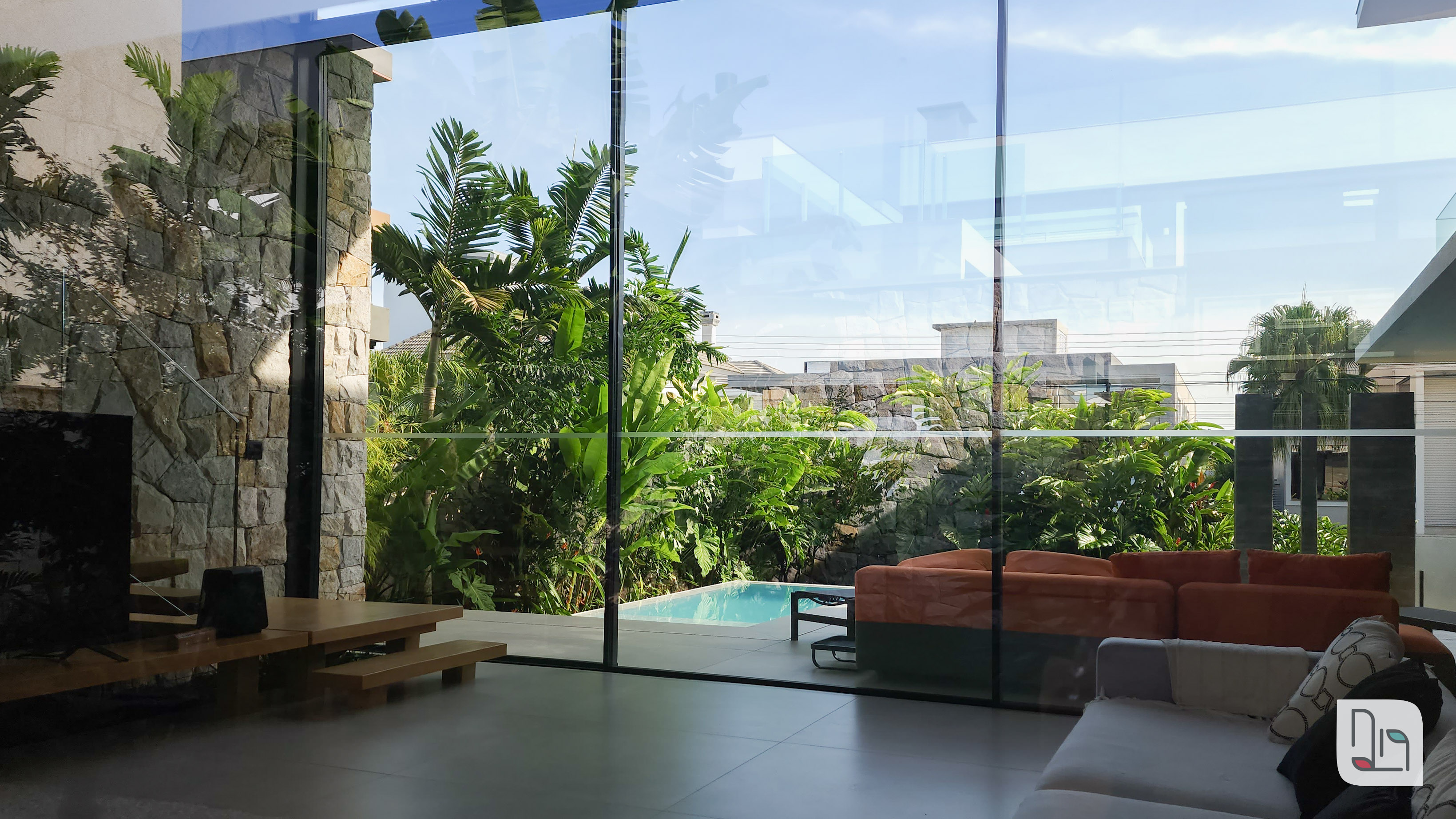 casa envidraçada com vista para a rua e piscina na frente